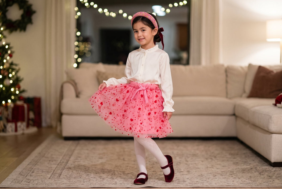 Pembe tütü etekli, bordo kadife fiyonklu ve confetti taçlı kız profilden